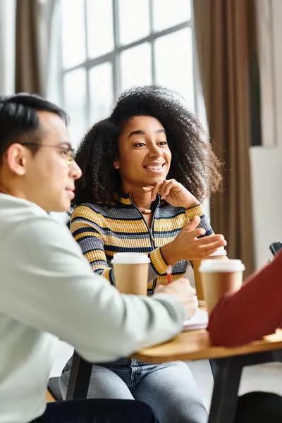 Un groupe multiculturel d'étudiants, y compris des membres de race blanche, asiatique et afro-américaine, ont pris part à une discussion à une table. — Photo de stock