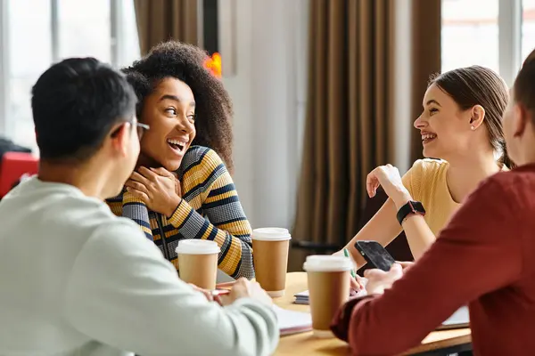 A diverse group of students engaging in a lively discussion around a wooden table in a university setting. — Stock Photo
