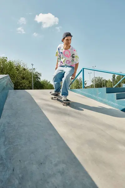 A young skater boy skillfully rides a skateboard down the side of a ramp in a skate park on a sunny summer day. — Stock Photo