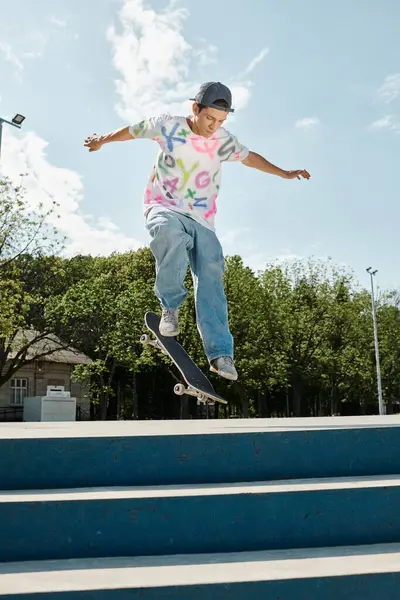 A young man rides a skateboard at a skate park on a sunny day, showcasing his skills and fearlessness. — Stock Photo