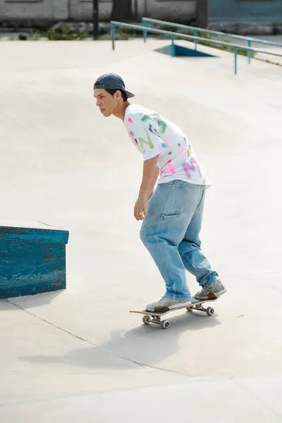 Молодий ковзаняр їде на скейтборді вниз по цементній рампі в ковзанярні в сонячний літній день. — стокове фото