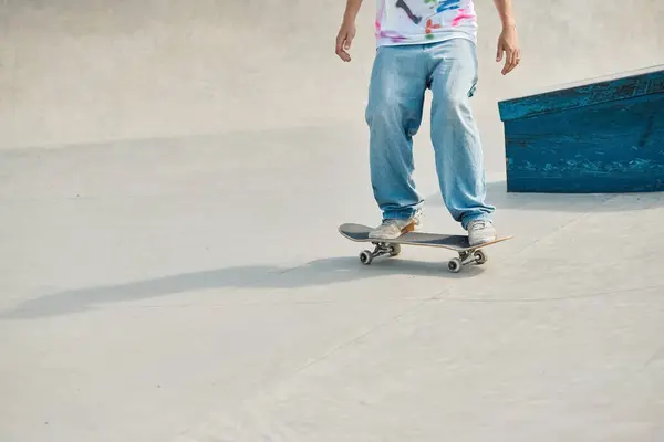 Ein junger Skater-Junge fährt an einem sonnigen Sommertag mit einem Skateboard eine Betonrampe in einem lebhaften Outdoor-Skatepark hinunter. — Stockfoto