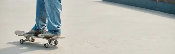 Un jeune garçon patineur manœuvre habilement son skateboard sur un trottoir animé de la ville par une journée d'été ensoleillée. — Photo de stock