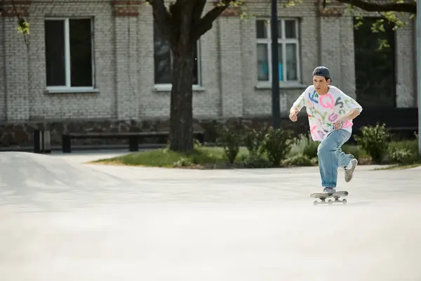 A young skater boy riding a skateboard down the street on a sunny summer day. — Stock Photo