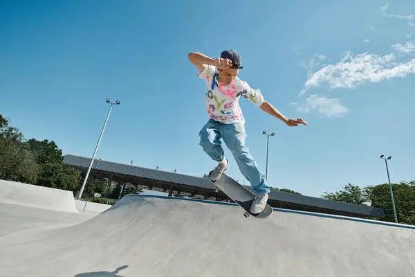 Ein junger Mann skatet selbstbewusst die Seite einer Rampe in einem sonnigen Outdoor-Skatepark hinunter und zeigt sein Geschick und seine Leidenschaft für den Sport. — Stockfoto