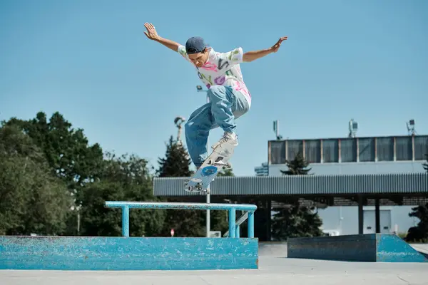 Un joven patinador desafía la gravedad mientras se eleva por el aire en su monopatín en un soleado parque de skate al aire libre. - foto de stock