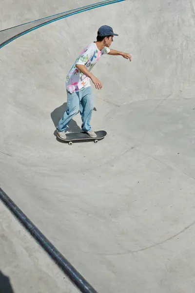 Um jovem imprudentemente monta um skate em uma rampa íngreme no sol de verão em um parque de skate. — Fotografia de Stock