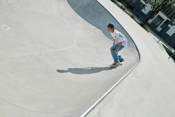 Ein junger Skater-Junge fährt an einem Sommertag in einem sonnigen Outdoor-Skatepark mit einem Skateboard eine Rampe hinauf. — Stockfoto