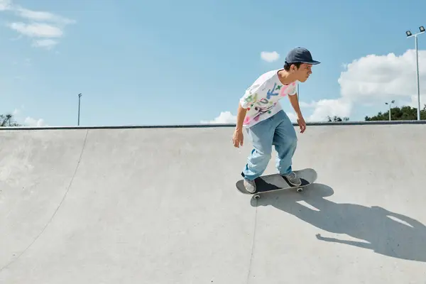Ein junger Mann fährt an einem sonnigen Sommertag selbstbewusst mit einem Skateboard eine steile Rampe in einem Skatepark hinauf. — Stockfoto