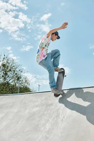 Un giovane skater boy cavalca impavido il suo skateboard sul lato di una rampa in un parco di pattini all'aperto in una giornata estiva soleggiata. — Foto stock