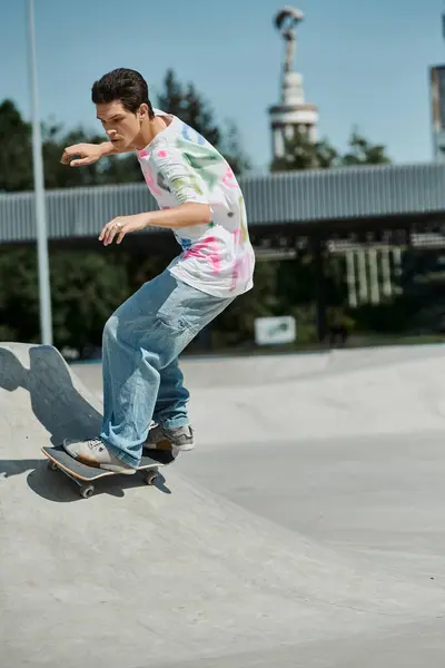 A young skater boy fearlessly rides his skateboard down the side of a ramp in a vibrant outdoor skate park on a sunny summer day. — Stock Photo