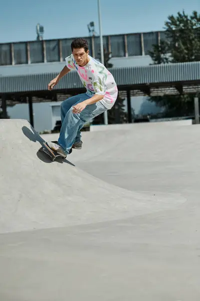 A fearless young skater boy defies gravity, riding his skateboard up the side of a ramp in a sunny outdoor skate park. — Stock Photo