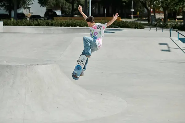 Um jovem desafia a gravidade enquanto habilmente monta seu skate até a rampa em um vibrante parque de skate ao ar livre em um dia de verão. — Fotografia de Stock