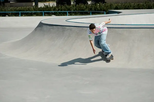 Um jovem skatista monta confiantemente seu skate até uma rampa íngreme em um parque de skate ao ar livre ensolarado. — Fotografia de Stock