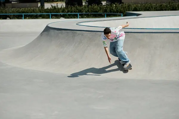 A young skater boy confidently rides his skateboard up a steep ramp in a sunny outdoor skate park. — Stock Photo