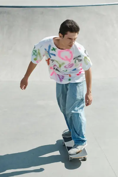 Un jeune homme chevauche habilement une planche à roulettes sur une rampe dans un skate park extérieur par une journée d'été ensoleillée. — Photo de stock