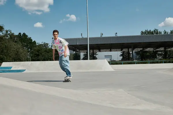 Ein wagemutiger junger Skater-Junge fährt furchtlos mit seinem Skateboard die Seite einer Rampe in einem sonnigen Outdoor-Skatepark hinunter. — Stockfoto