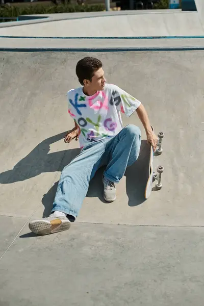 Un joven hábilmente monta su monopatín al lado de una rampa en un vibrante parque de skate al aire libre en un soleado día de verano.. - foto de stock