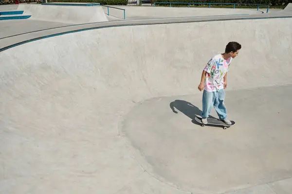 Ein junger Skater-Junge manövriert an einem sonnigen Sommertag sein Skateboard in einem belebten Skatepark. — Stockfoto
