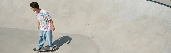 Молодий ковзаняр обманює гравітацію, коли він їде на скейтборді в рамп у сонячному відкритому скейт-парку в літній день. — стокове фото