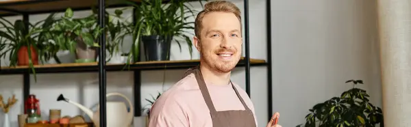 A confident man wearing an apron gives a thumbs up in a plant shop, embodying the spirit of owning a small business. — Stock Photo