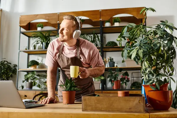 Un homme avec un casque travaille sur un ordinateur portable à une table. — Photo de stock