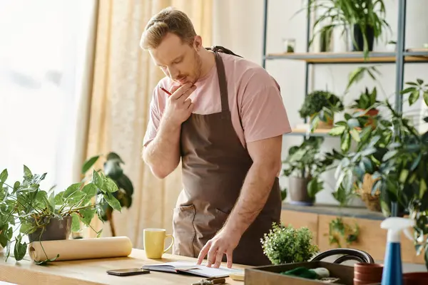 A stylish man tends to his lush plant collection at his own florist shop, embodying the spirit of entrepreneurship and nature. — Stock Photo