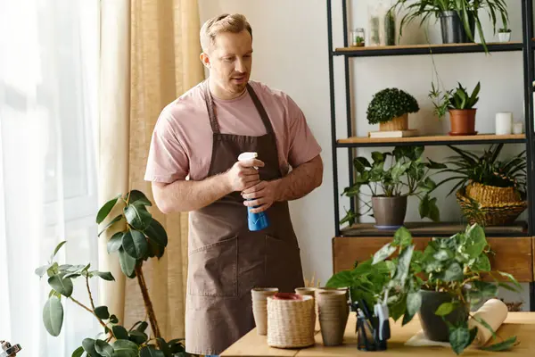 A man tends to potted plants on a table in a botanical setting. — Stock Photo