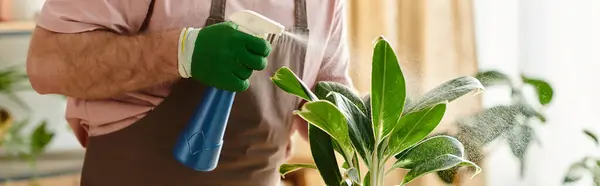 Un hombre delicadamente sostiene un pincel junto a una hermosa planta en maceta en su tienda de plantas, mostrando su pasión por el arte botánico. - foto de stock