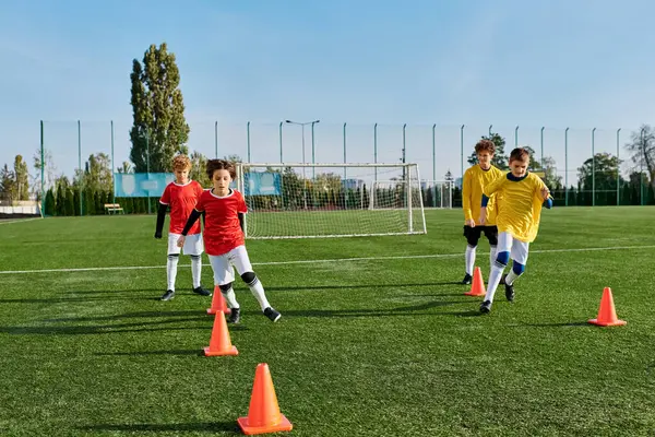 Un groupe de jeunes garçons jouant avec enthousiasme au football sur un terrain vert. Ils dribblent, passent, et tirent la balle avec excitation et joie. — Photo de stock