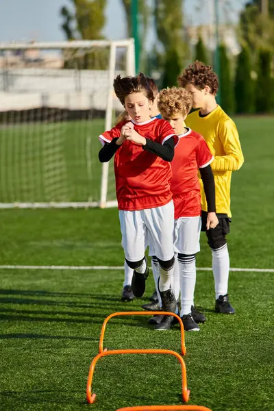Un groupe diversifié de jeunes garçons se tiennent énergiquement au sommet d'un terrain de soccer dynamique, mettant en valeur leur travail d'équipe et leur camaraderie alors qu'ils se préparent à jouer un match amical animé. — Photo de stock