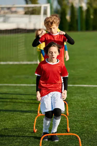 Crianças pequenas jogam energeticamente um jogo de futebol, correndo, chutando e passando a bola com entusiasmo e trabalho em equipe. — Fotografia de Stock