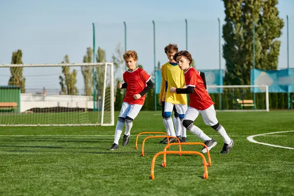 Eine Gruppe junger Jungen spielt begeistert Fußball, kickt den Ball hin und her, sprintet über das Feld und feiert freudig die erzielten Tore.. — Stockfoto
