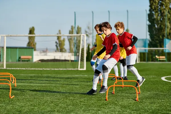 A group of energetic young boys playing a game of soccer in a grassy field, kicking the ball, running, and laughing together as they compete in a friendly match. — Stock Photo