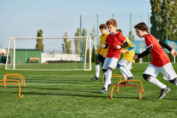 A lively group of young boys engaged in a competitive game of soccer, running, kicking, and passing the ball on a vibrant field. — Stock Photo