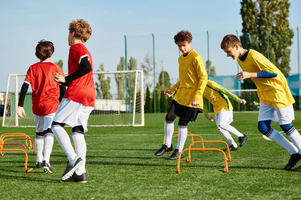 Динамічна сцена групи молодих чоловіків, які займаються захоплюючою грою в футбол, бігають, проходять і штовхають м'яч з точністю і навичками на яскравому полі. — стокове фото
