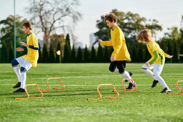 A lively group of young children joyfully engage in a spirited game of soccer, running, kicking, and passing the ball on a grassy field. Their faces show excitement and determination as they compete in friendly yet competitive spirit. — Stock Photo