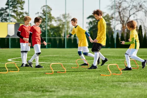 A lively group of young boys engage in a spirited game of soccer, kicking the ball across the field with enthusiasm and skill. Laughter fills the air as they run, dribble, and score goals in a joyful display of sportsmanship and camaraderie. — Stock Photo