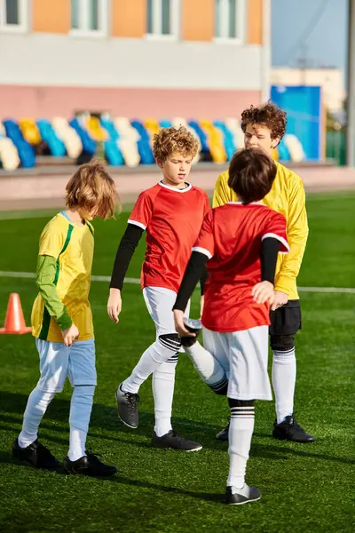 Un grupo de chicos jóvenes absortos en un animado juego de fútbol, correr, patear y animar en el campo con puro entusiasmo y alegría. - foto de stock