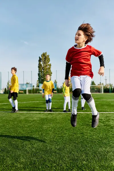 Um grupo de crianças pequenas, cheio de energia e emoção, está envolvido em um jogo amigável de futebol em um campo verde alastrando. Eles correm, chutam, passam e se alegram sob o sol quente. — Fotografia de Stock