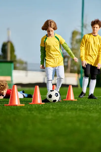 A group of young children, filled with enthusiasm, are engaged in a lively game of soccer. They are running, kicking the ball, laughing, and cheering each other on. The sun is shining brightly, casting long shadows on the grassy field. — Stock Photo