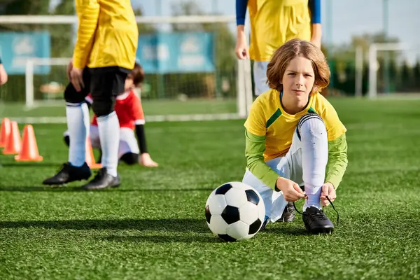 Молодая девушка энергично играет в футбол на поле, уверенно капает мяч и целится в ворота. Ее глаза наполнены решимостью, так как она демонстрирует свои навыки и страсть к спорту. — стоковое фото