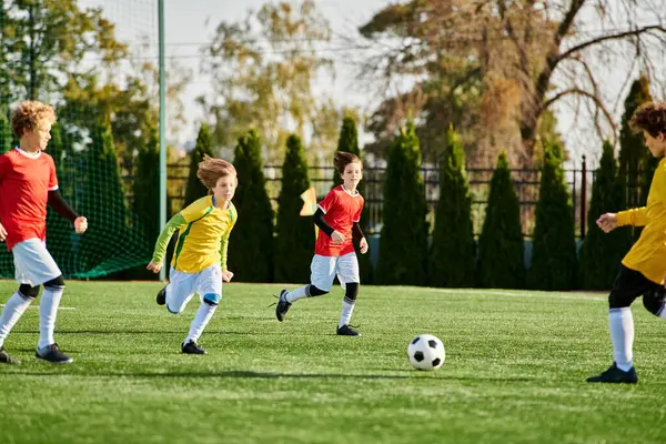 Um grupo de jovens enérgicos está jogando um jogo emocionante de futebol, chutando uma bola ao redor com entusiasmo e riso em um campo gramado. — Fotografia de Stock