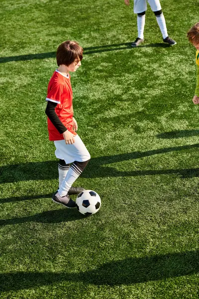 Dos jóvenes enérgicos en acción, pateando una pelota de fútbol alrededor de un campo con emoción y entusiasmo. Su espíritu lúdico y competitivo brilla mientras disfrutan del juego juntos. - foto de stock