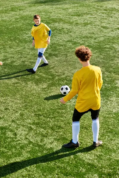 Un groupe animé de jeunes hommes engagés dans un jeu compétitif de football sur un terrain animé. Ils courent, passent et tirent la balle avec énergie et enthousiasme. — Photo de stock