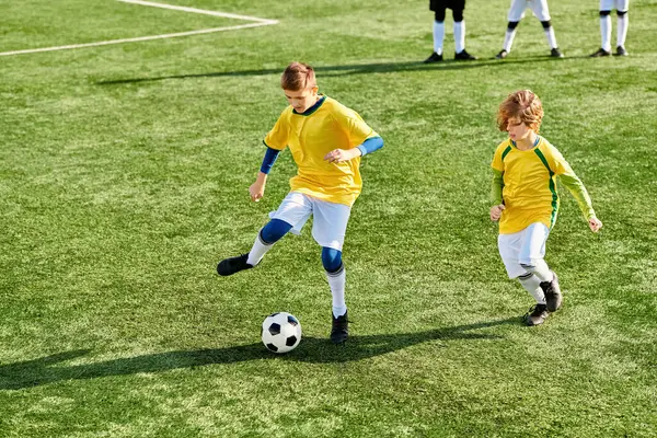 Una escena vibrante se desarrolla cuando un grupo dinámico de jóvenes participan en un estimulante juego de fútbol, mostrando sus habilidades, trabajo en equipo y pura alegría de jugar juntos.. - foto de stock