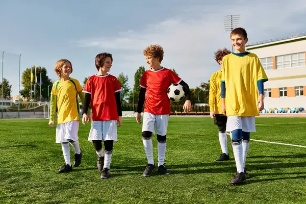 Un gruppo di bambini in piedi orgogliosi su un campo da calcio, che festeggiano la loro vittoria con sorrisi e cinque. — Foto stock