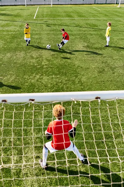 Un gruppo di bambini piccoli, pieni di energia ed entusiasmo, che giocano un'emozionante partita di calcio. Corrono, prendono a calci la palla e si tifano a vicenda mentre si impegnano in una competizione amichevole sul campo.. — Foto stock