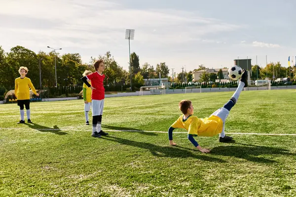 Eine bunte Gruppe junger Menschen spielt ein intensives Fußballspiel auf einer grünen Wiese. Sie dribbeln, passen und schießen den Ball, zeigen ihr Geschick und Teamwork. — Stockfoto