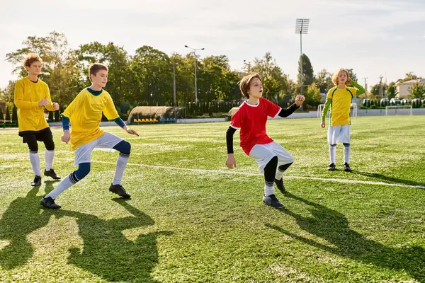 Un groupe vivant de jeunes gens s'engagent dans un jeu amical de football, courir, donner des coups de pied et passer le ballon avec enthousiasme et habileté. — Photo de stock